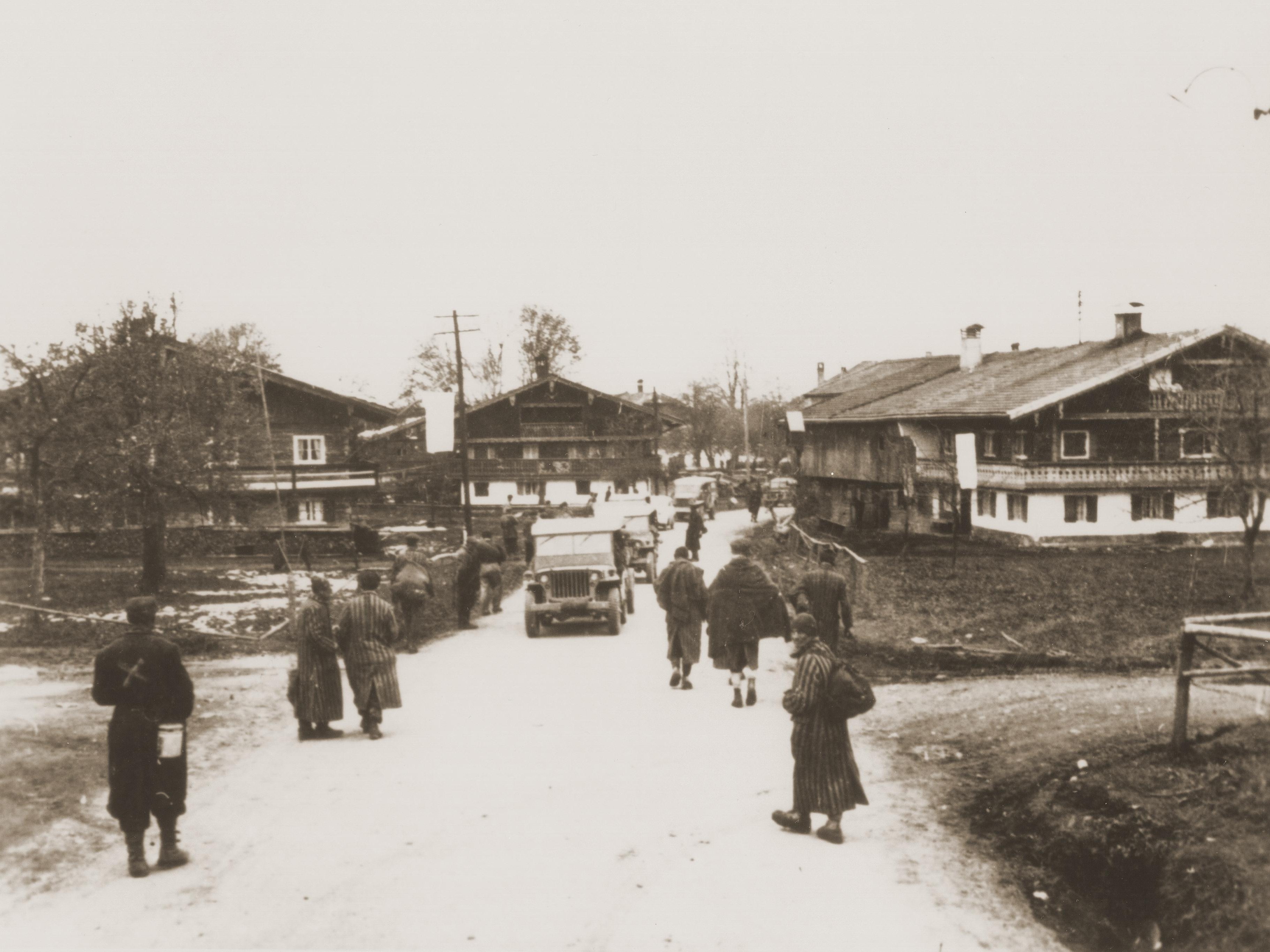 Überlebende, die von japanisch-amerikanischen Truppen des 522nd Field Artillery Battalion befreit wurden, säumen die Straße in Waakirchen, wo die US-Streitkräfte ein Feldlazarett zu ihrer Versorgung einrichteten.