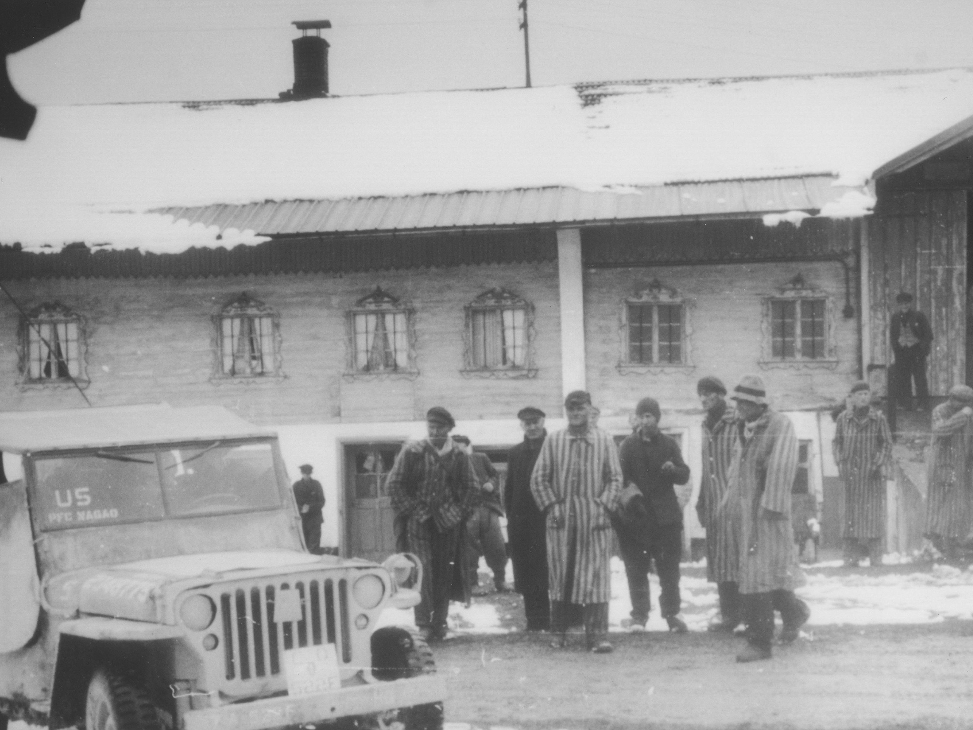 Befreite Häftlinge des Todesmarsches von Dachau stehen vor einer Scheune in Waakirchen, wo japanisch-amerikanische Soldaten des 522nd Field Artillery Battalion ihnen Unterschlupf gewährten. | Fotograf: George Oiye